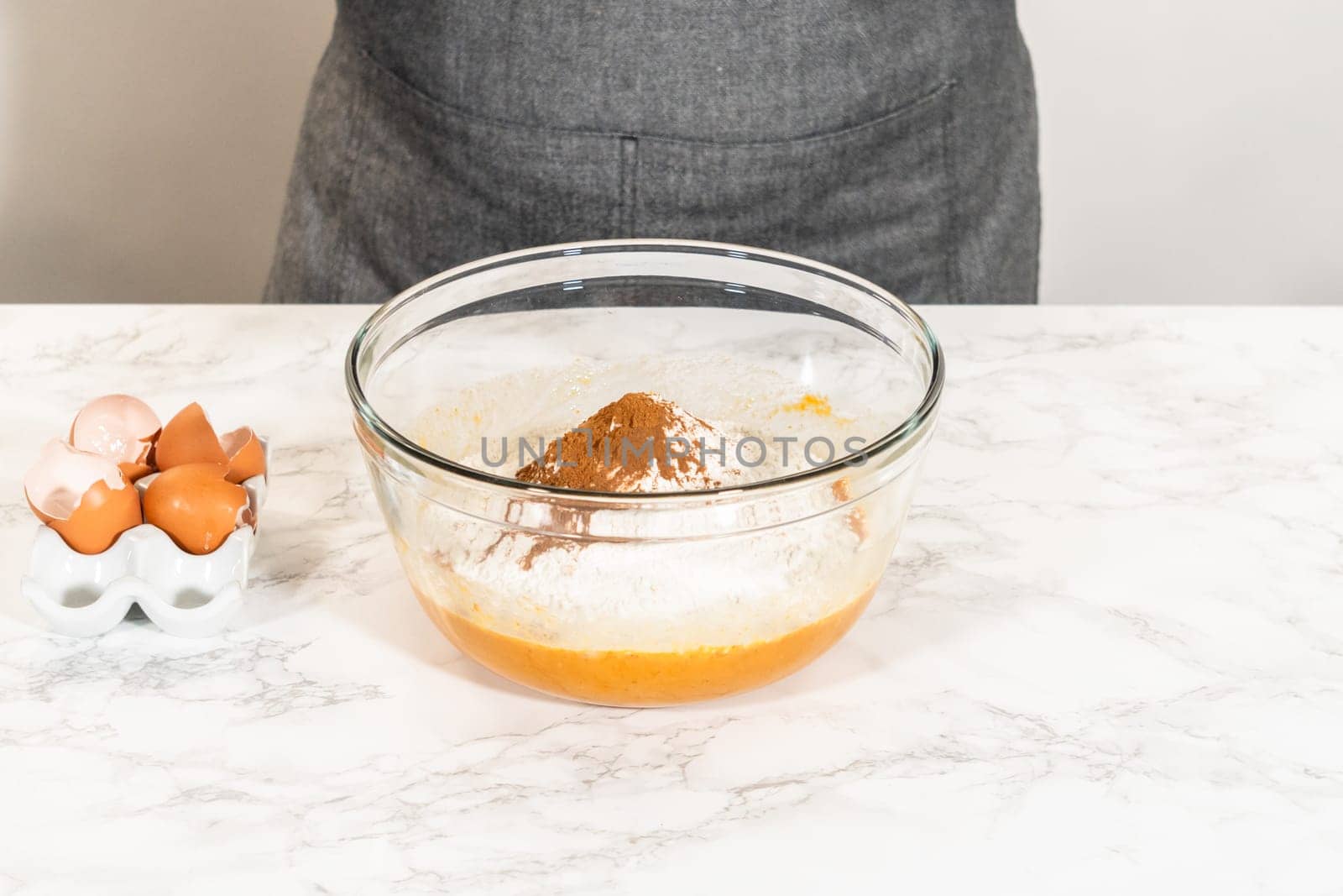 In a cozy kitchen, a large mixing bowl becomes the stage for expertly blending the ingredients, setting the scene for crafting a delightful homemade pumpkin bundt cake from cake mix.
