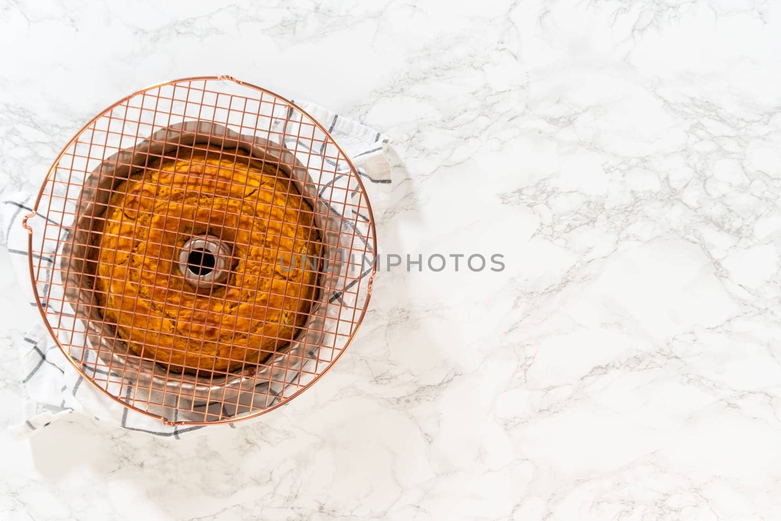Flat lay. Cooling freshly baked pumpkin bundt cake on the kitchen counter.