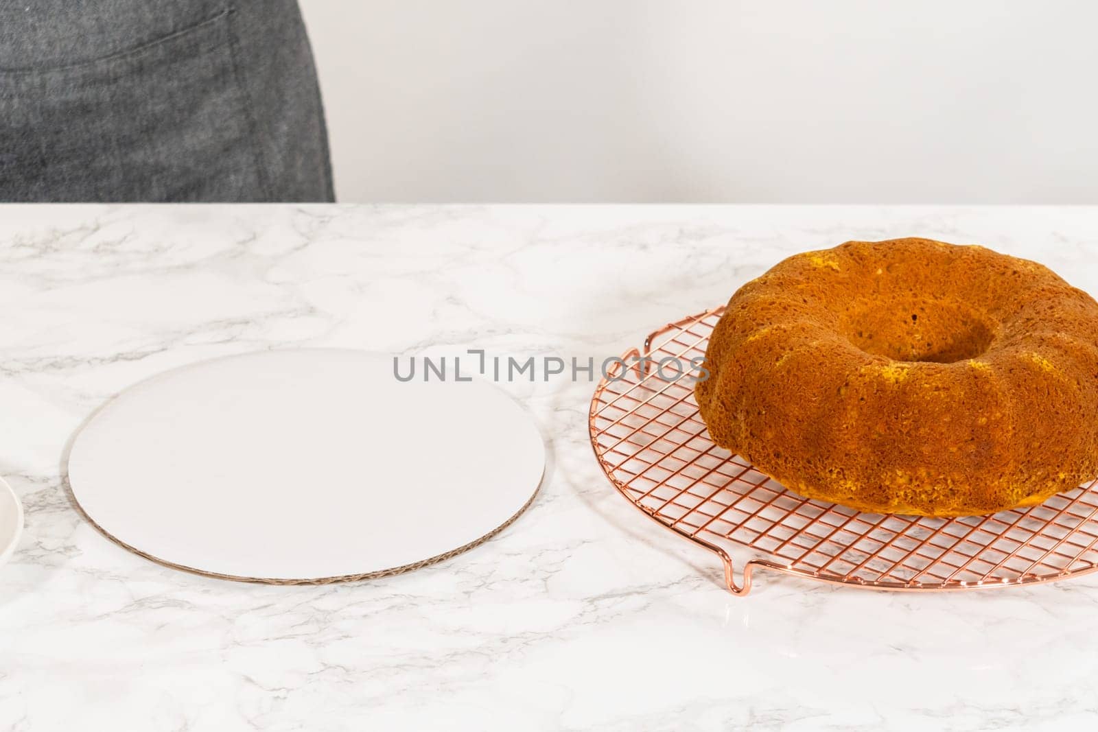Icing the pumpkin bundt cake with cream cheese frosting and decorating it with chocolate leaves.