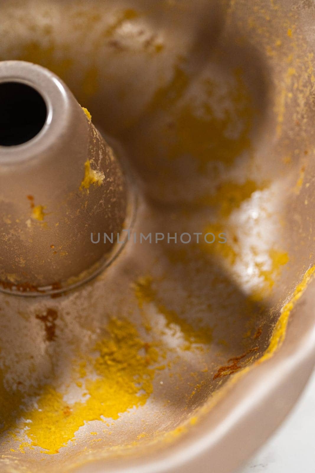 A close-up view of a dirty bundt cake pan after baking the pumpkin bundt cake.