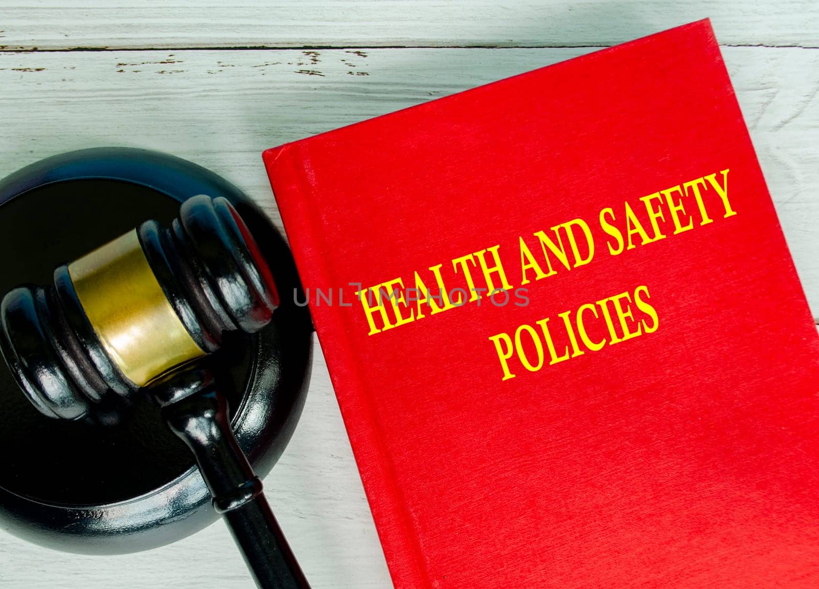 Top view of Health and Safety policies text on red cover book with gavel background. HSE concept.