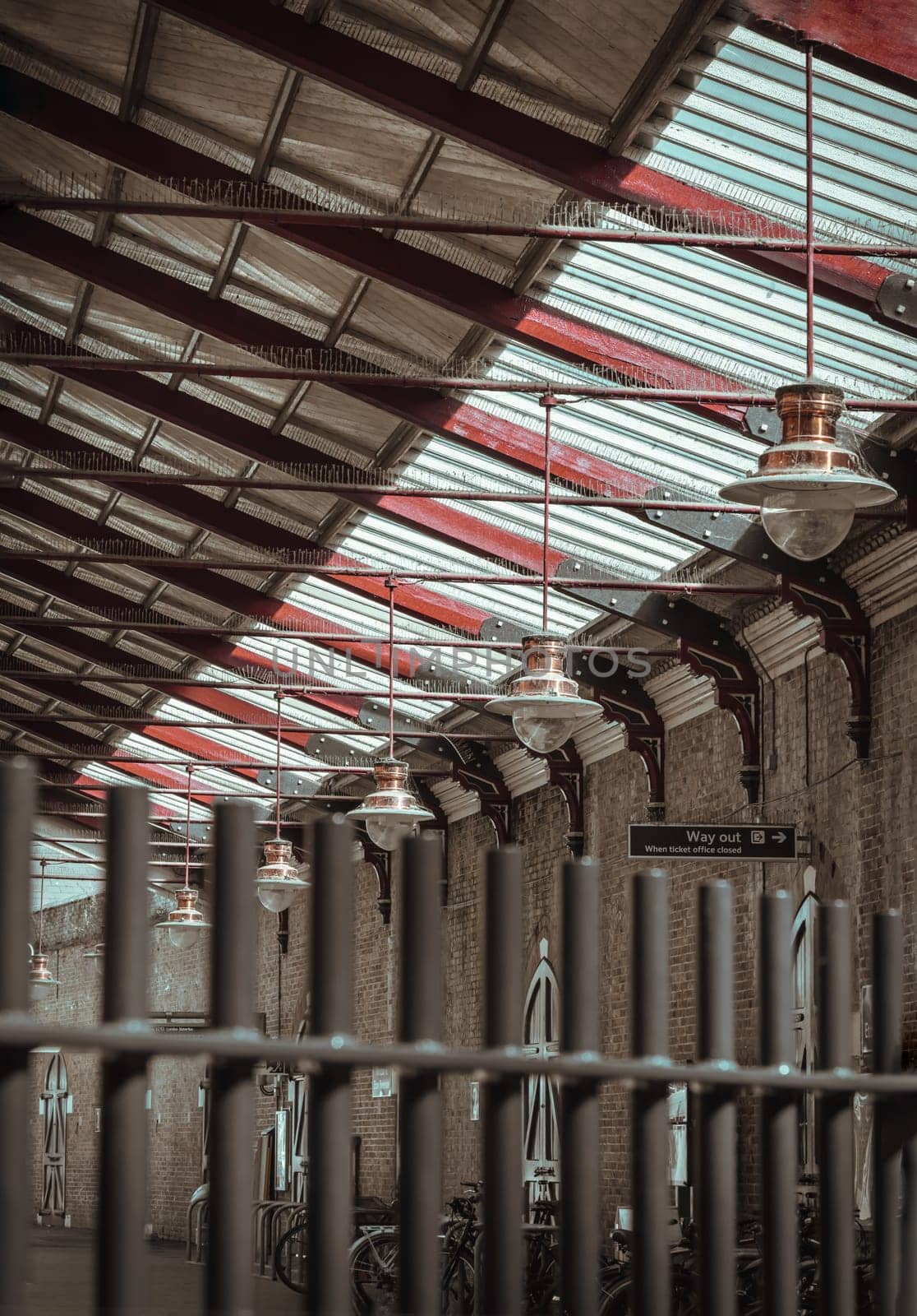 Windsor, UK - Apr 3, 2025 - A vintage copper ceiling light fixture with a glass globe shade hangs from a white ceiling and Wooden beams are visible creating a rustic yet elegant interior atmosphere at Windsor & Eton Riverside railway station. Paddington pendant light, use it as your Wallpaper, Poster and Space for text, Selective focus.