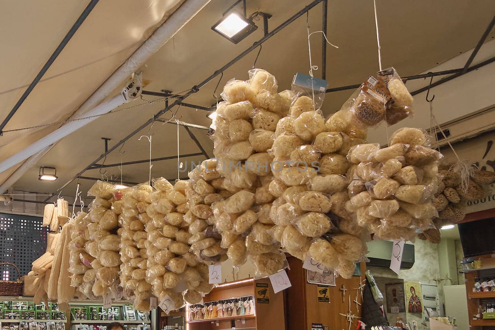 Crete, Greece - April 5, 2025: Mediterranean market shop featuring organic sea sponges arranged neatly, alongside fresh produce and cultural crafts, creating an authentic local experience.