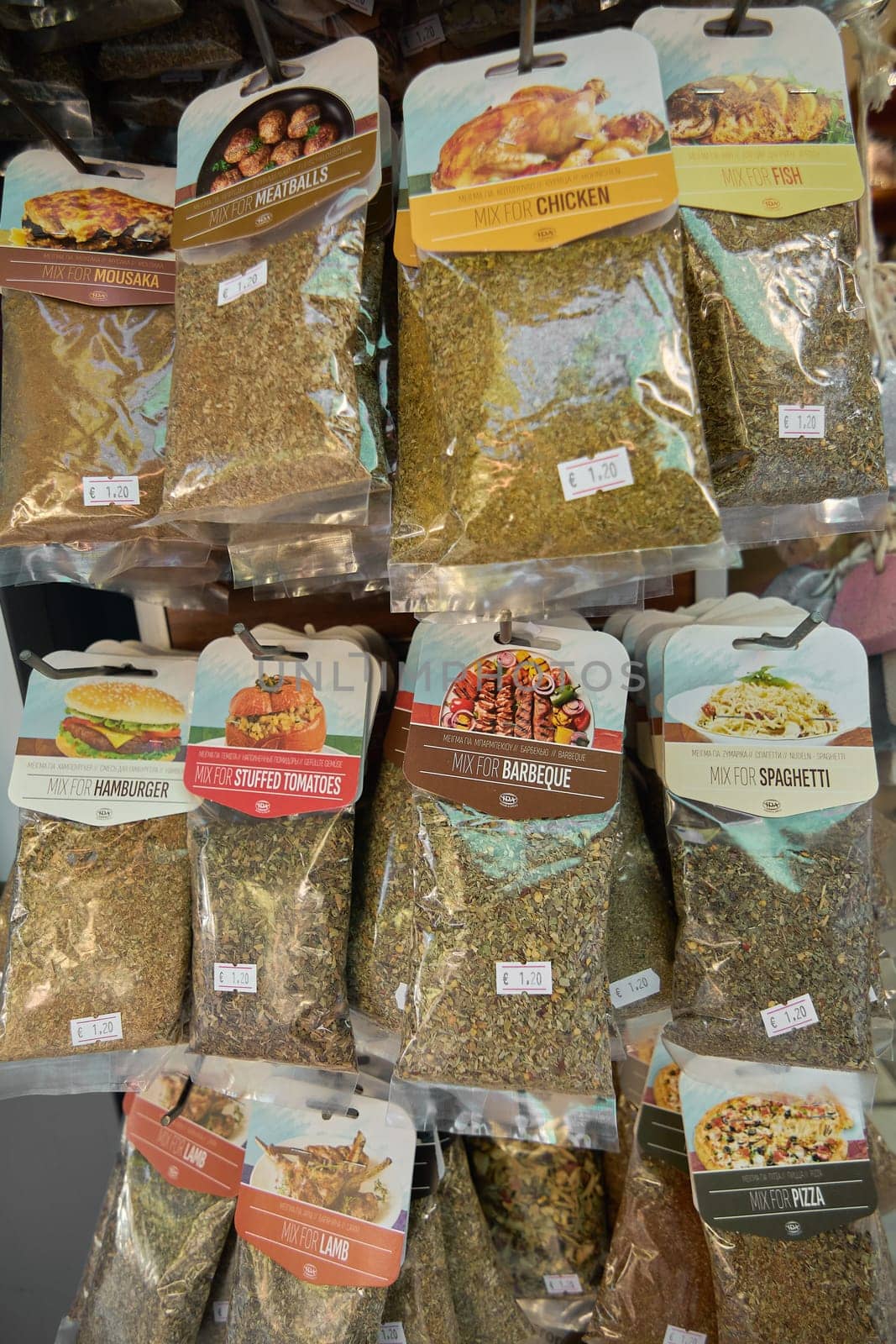 Crete, Greece - April 5, 2025: Assorted cooking herbs and spices with labels such as paprika, cumin, fish, and feta cheese seasoning, organized in rows to ensure easy selection and flavor exploration.