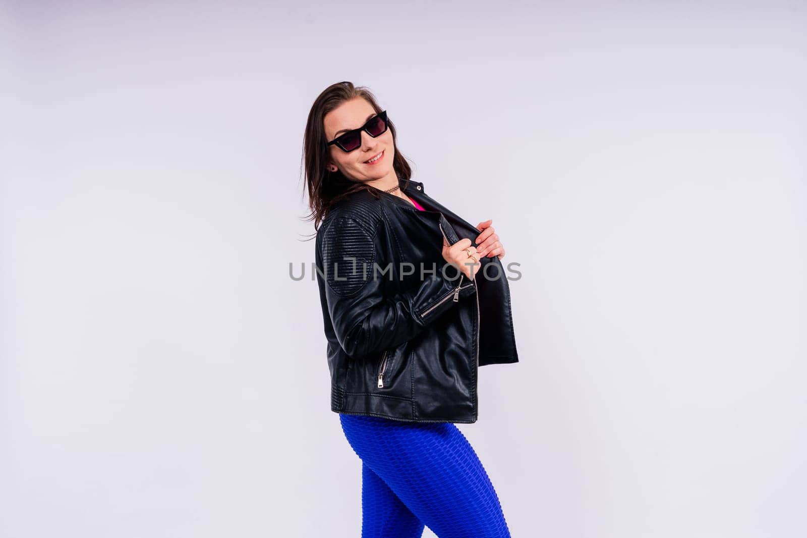 Active plus-size woman in a sport top and leggings. Fitness, body positive, emotions, weight loss.