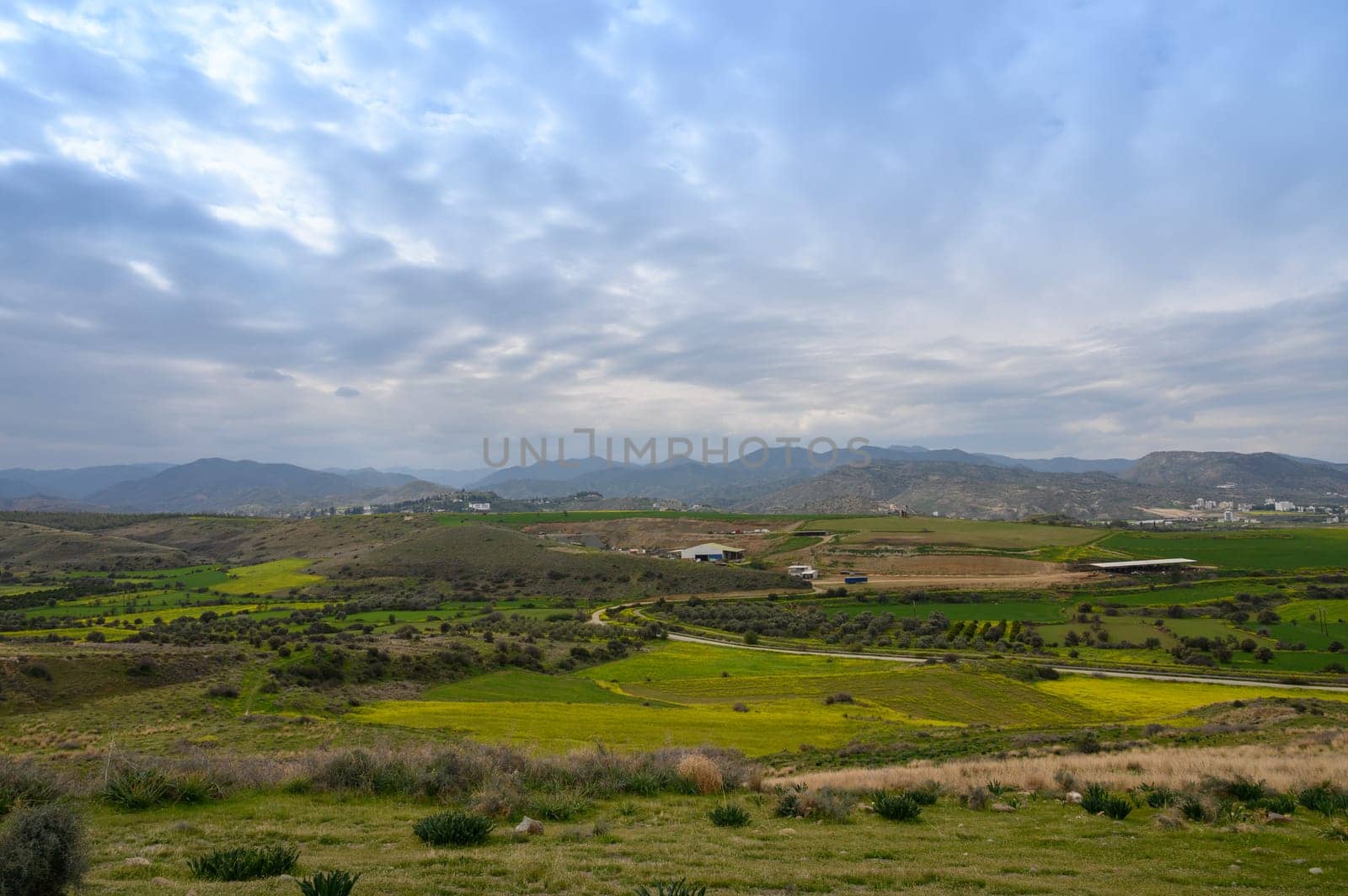Rolling green hills create a picturesque view as soft clouds drift overhead during the late afternoon. The tranquil countryside invites peaceful reflection and exploration of nature's beauty.