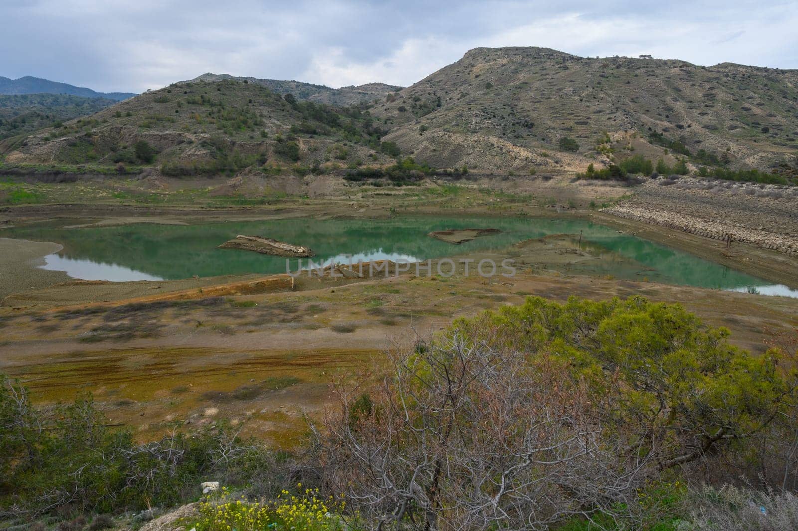 A tranquil vista unfolds with emerald waters reflecting the rugged hills.