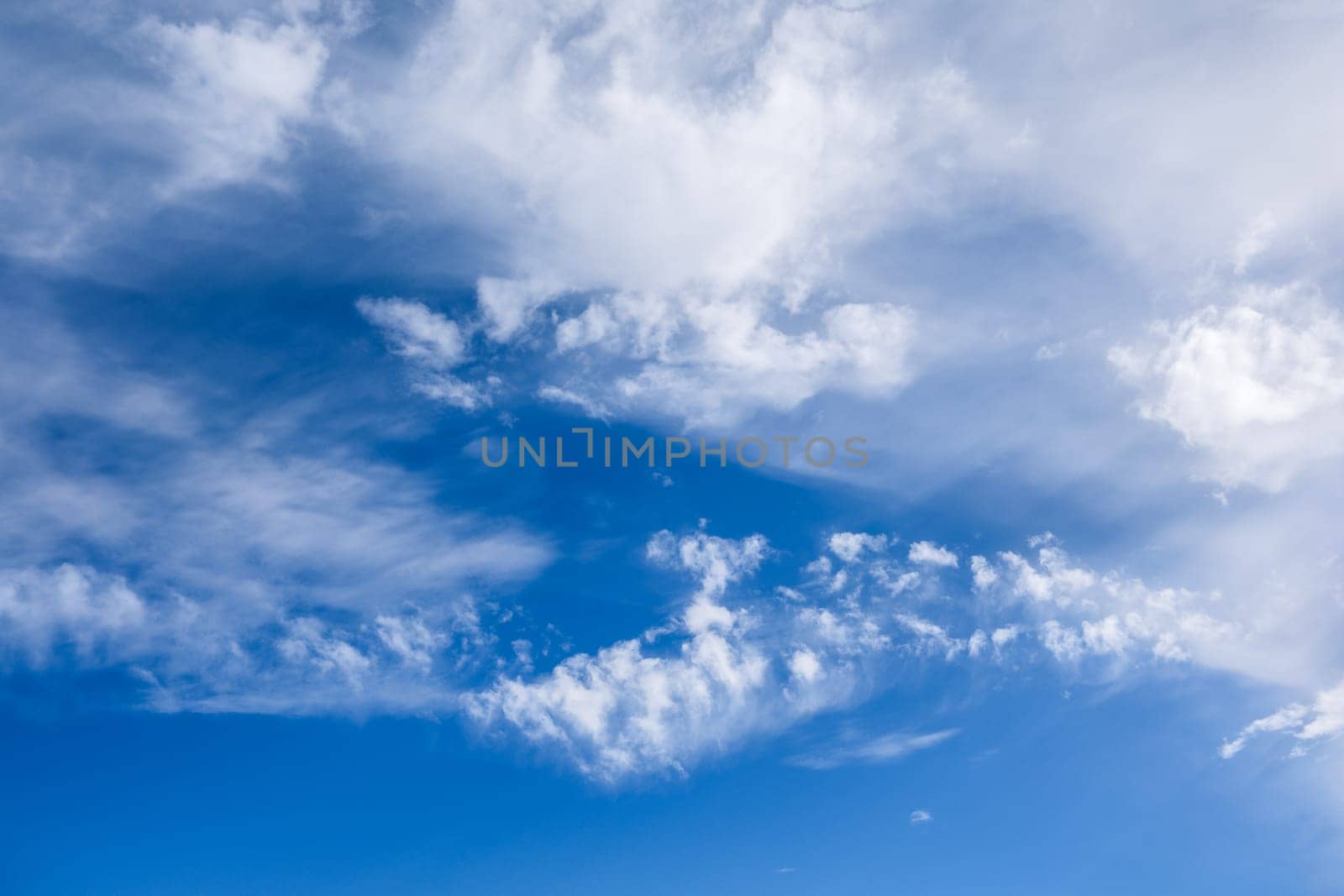 Beautiful white clouds gently float across a deep blue sky, creating a serene and picturesque scene