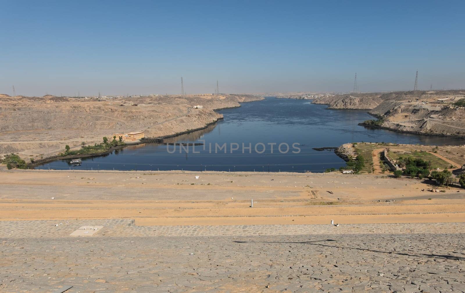 View down the sloping side of the Aswan Dam in Egypt at the river Nile flowing northwards towards the ocean