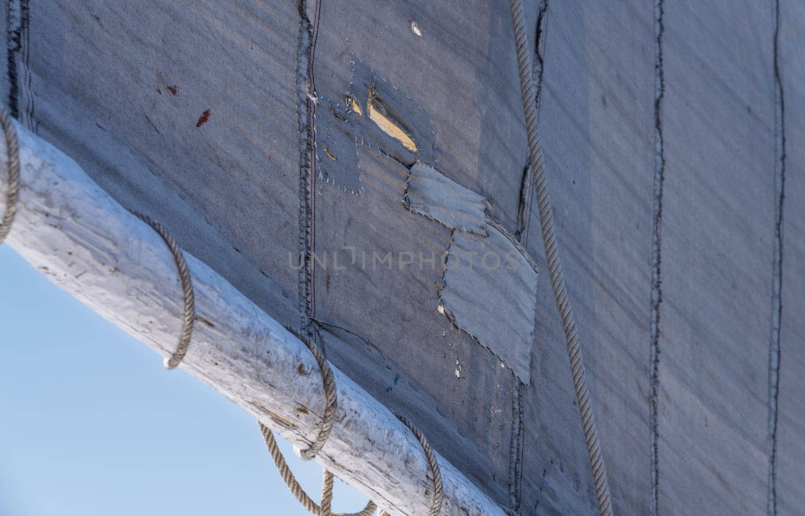 Details of ropes, mast and repaired sailcloth sail on worn felucca boat ready for cruise on Nile