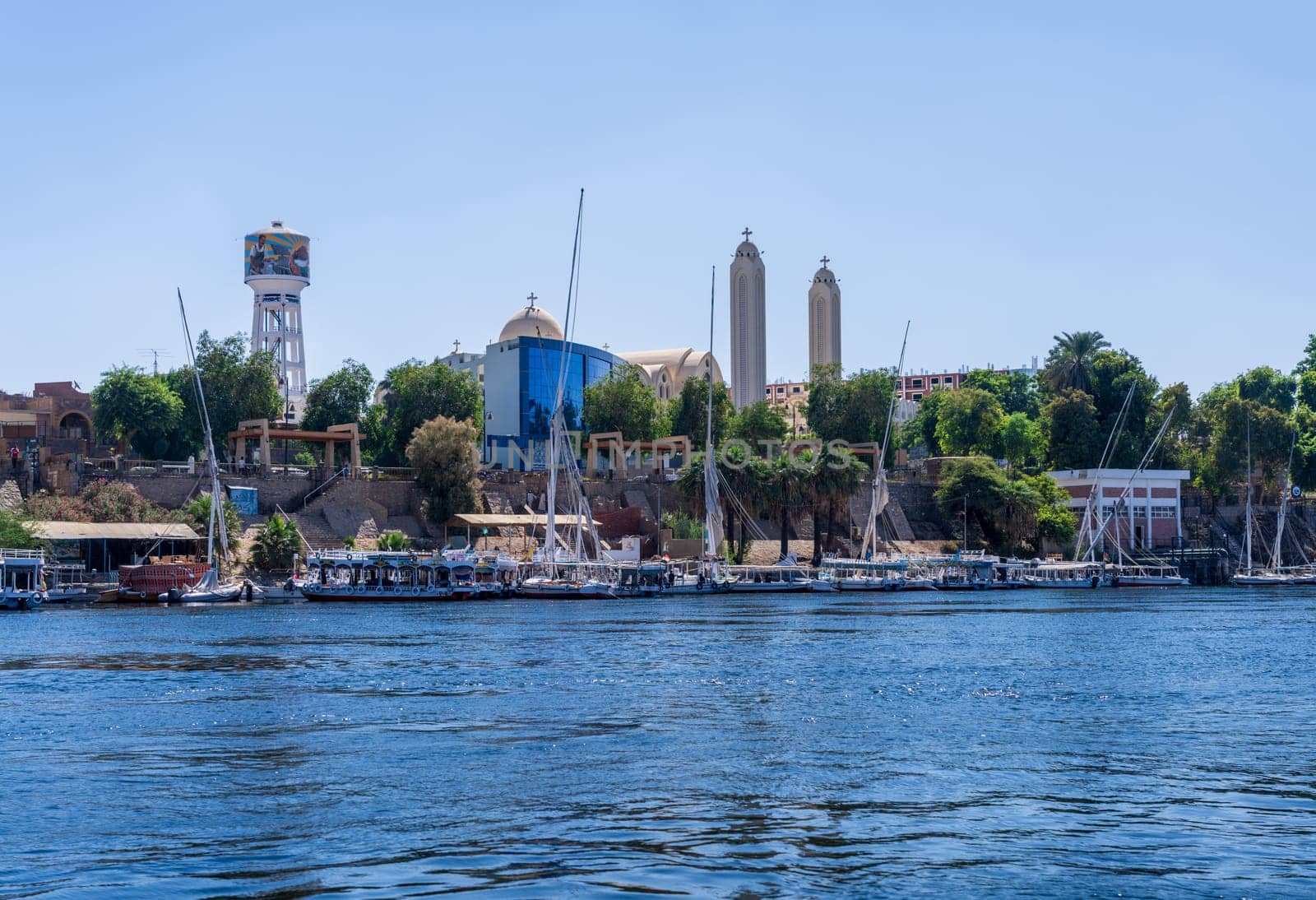 Aswan Archangel Michael Coptic orthodox cathedral on the shore with boats docked on the River Nile