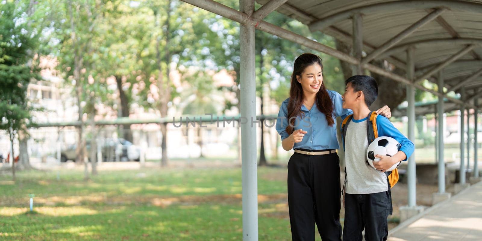 A parent and child enjoy a walk in a school environment, discussing their day, and experiencing the beauty of learning together.