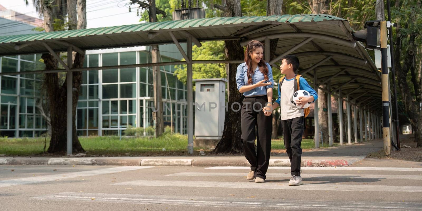 As they pause to cross the street, the mentor encourages the boy, reinforcing the importance of physical activity and friendship after school.