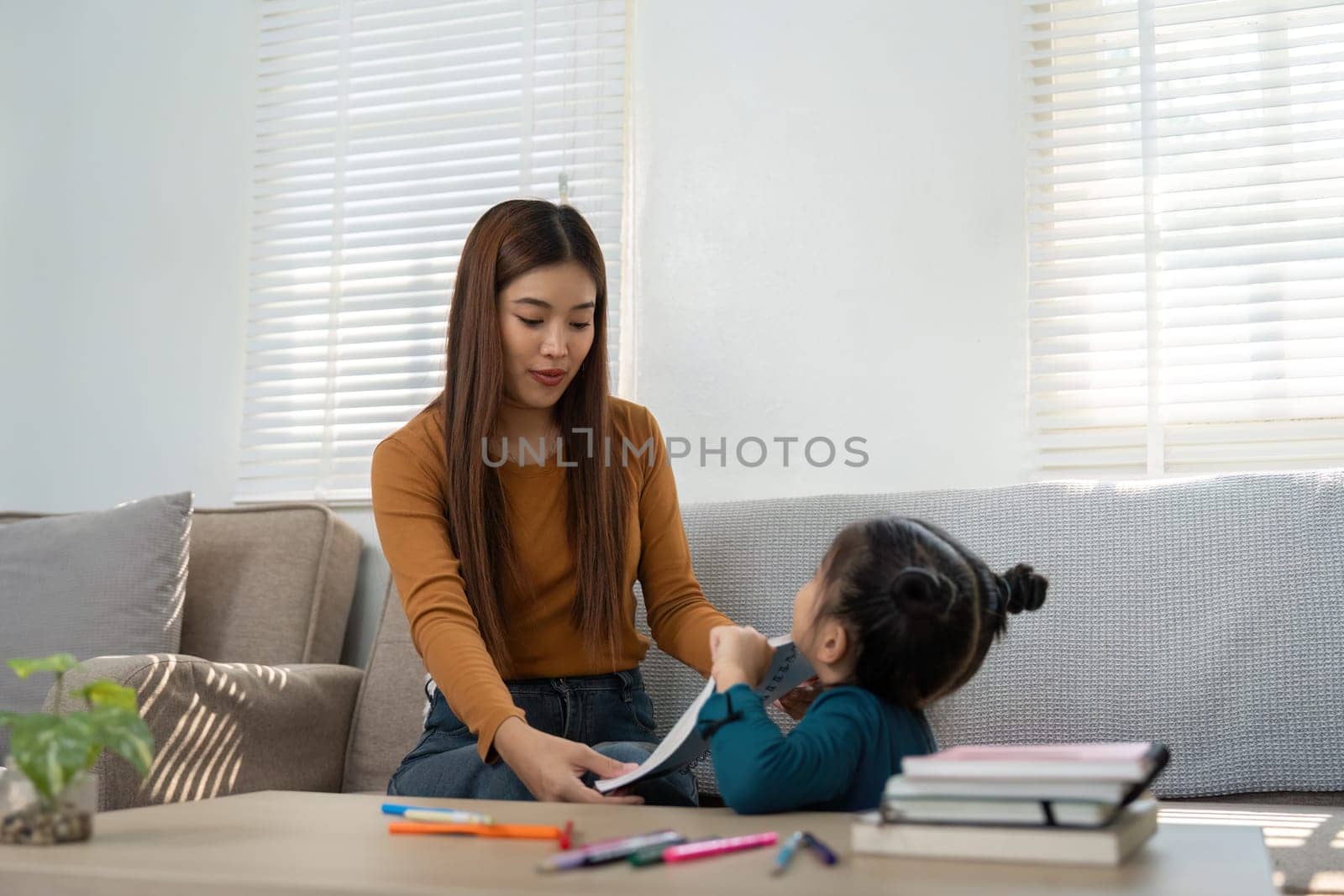 A mother shares learning moments with her daughter, connecting through educational tasks in a warm and inviting space.