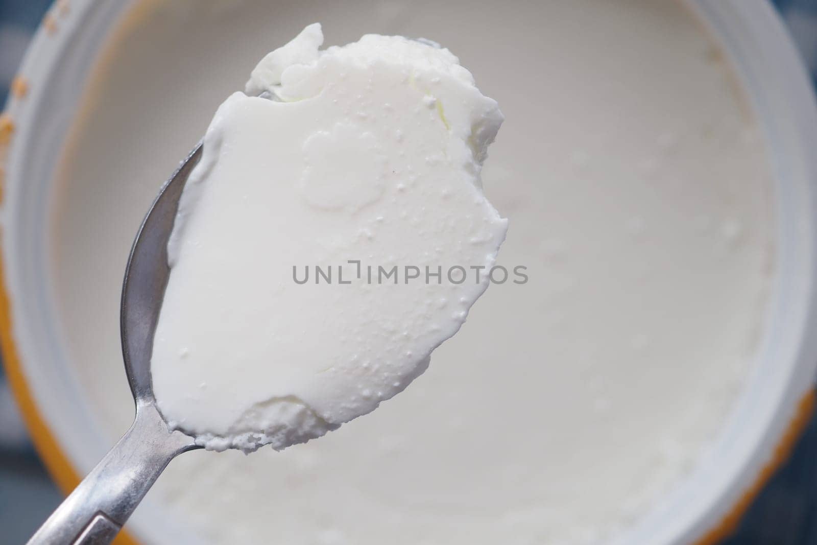 A spoon holds smooth and creamy yogurt ready to be enjoyed.