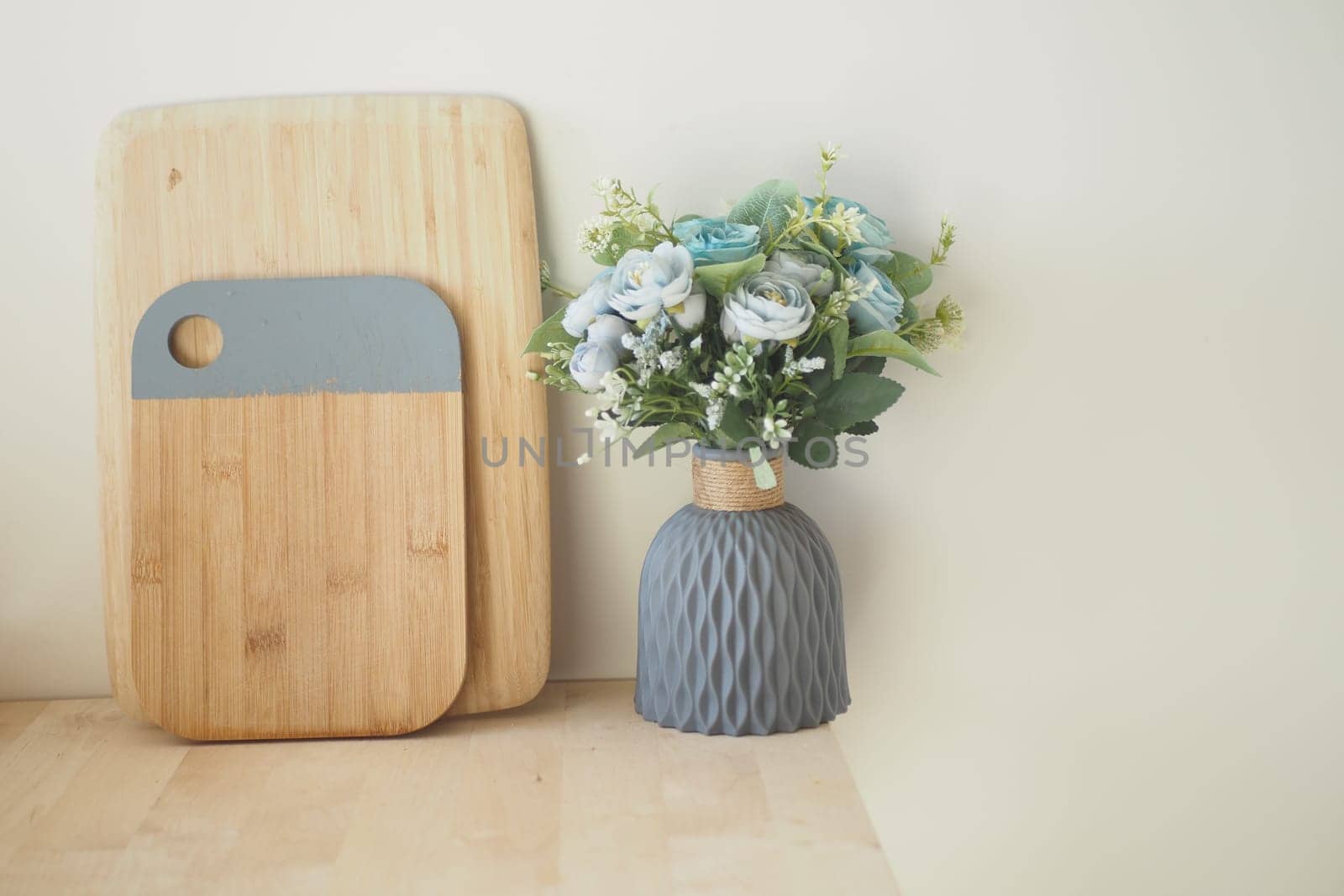 Stylish arrangement of cutting boards alongside a floral vase at home.