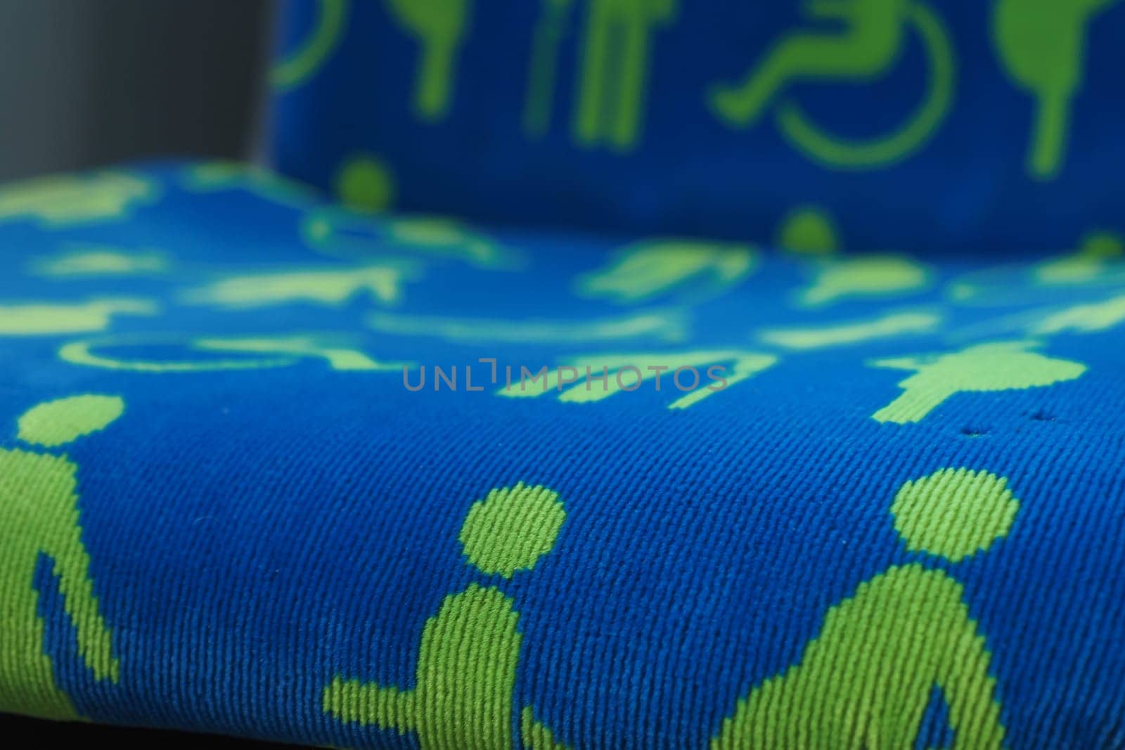 Colorful fabric features various accessibility symbols in green on blue.