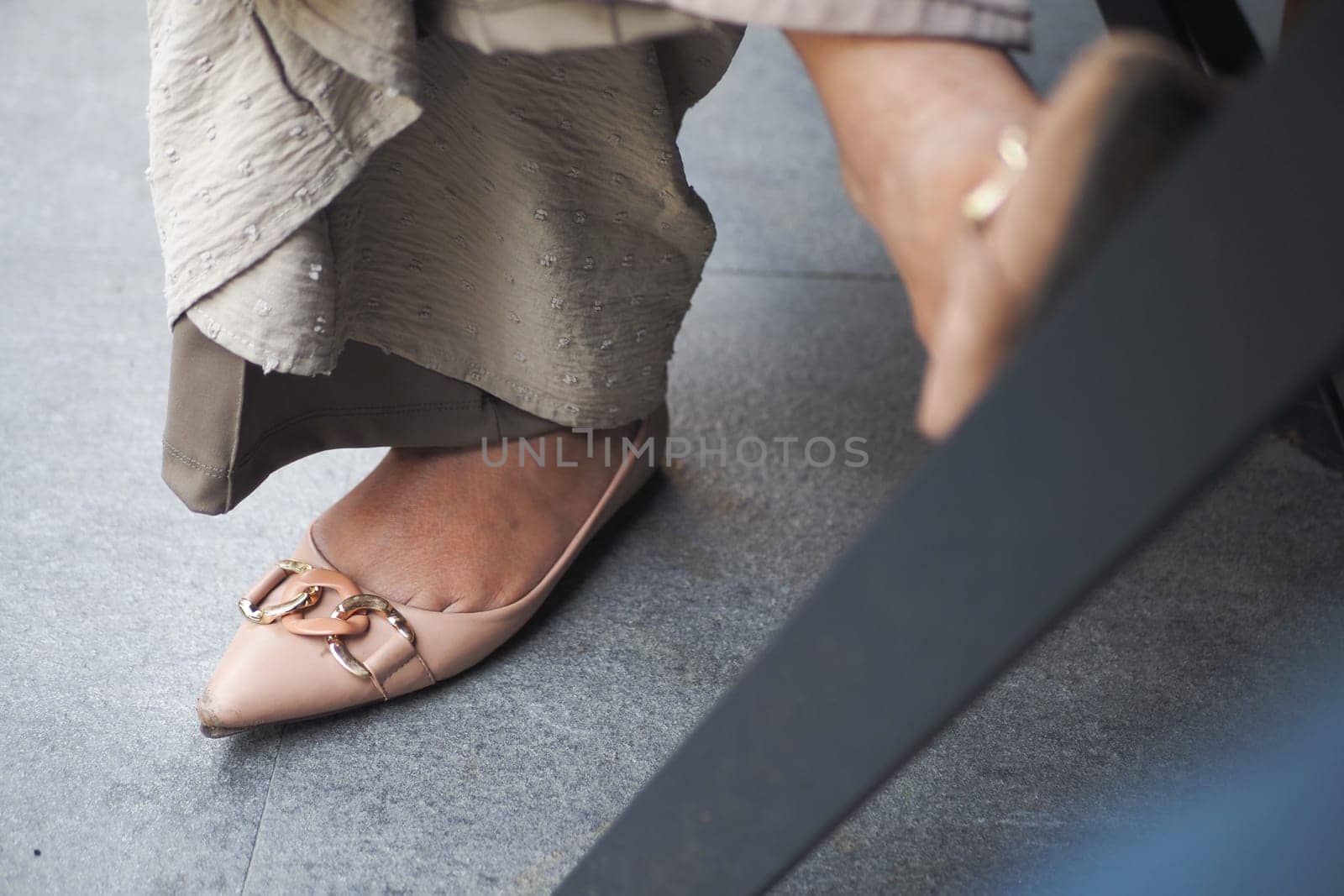 Delicate flats elegantly contrast with a textured outfit while sitting outdoors.