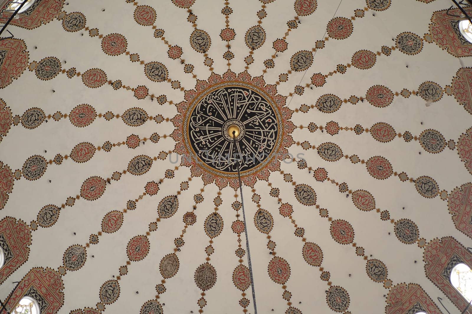 Visitors admire the stunning ceiling decorated with detailed patterns.