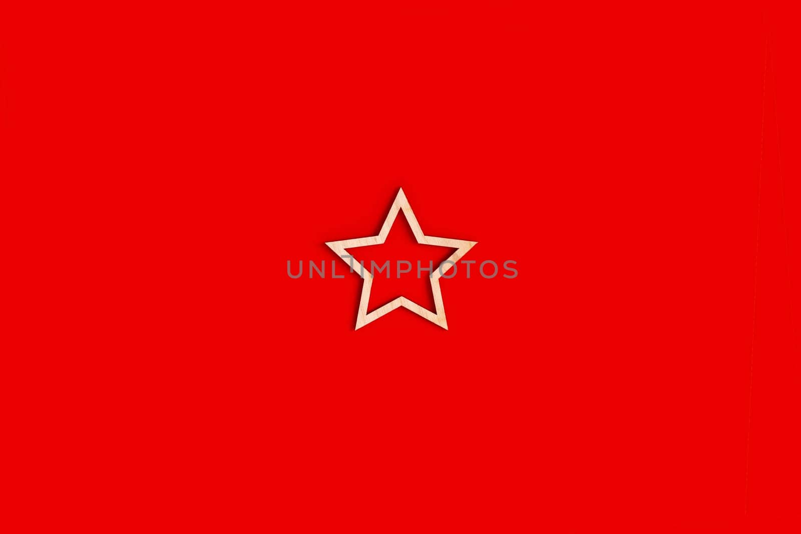One natural unpainted wooden star shape frame on red background. Close up. Mock up