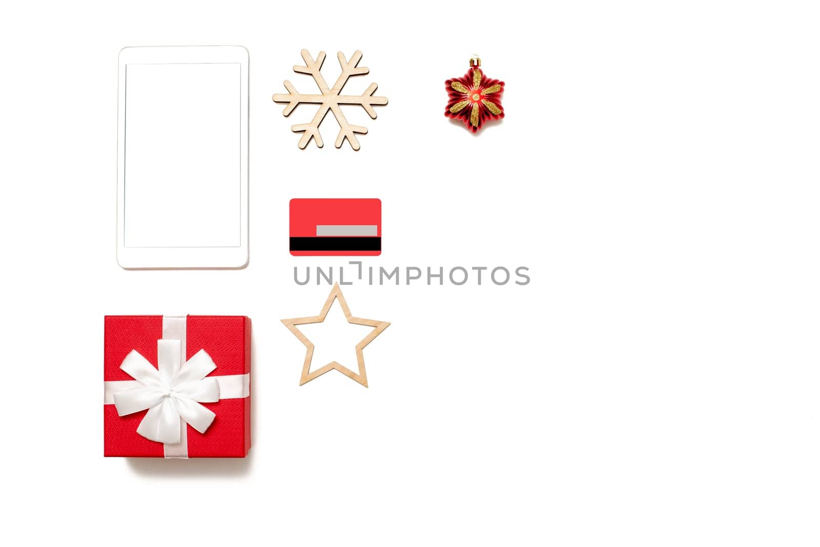 Top view of digital tablet screen with copy space on white desk table, credit card, gift box and Christmas toys. Online shopping concept at christmas. Mock up. Copy space