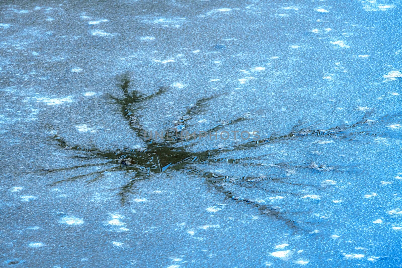 Abstract image of a crack in the ice cover of a muddy lake