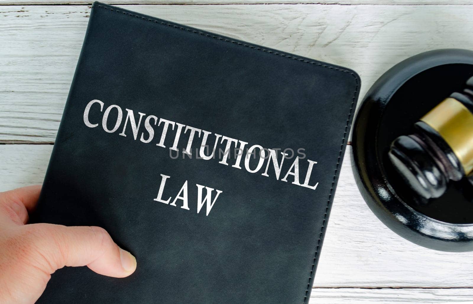 Top view of Constitutional Law book with gavel background.