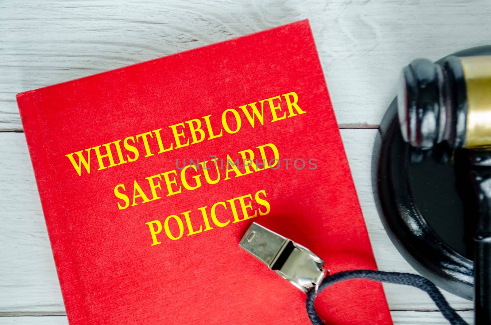 Top view of Whistleblower Safeguard Policies book with whistle and gavel background.