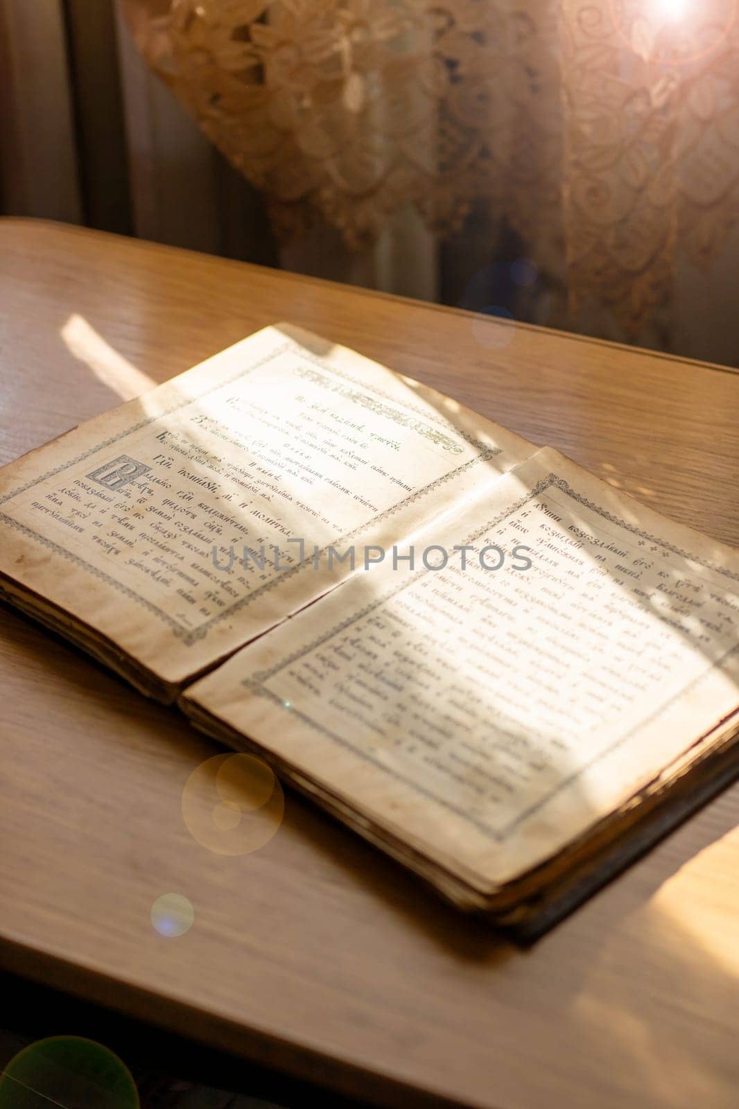 Belarus, Minsk - 09.03.2025: An ancient book, filled with stories from long ago, lies open upon a wellworn wooden table, inviting readers to explore its pages
