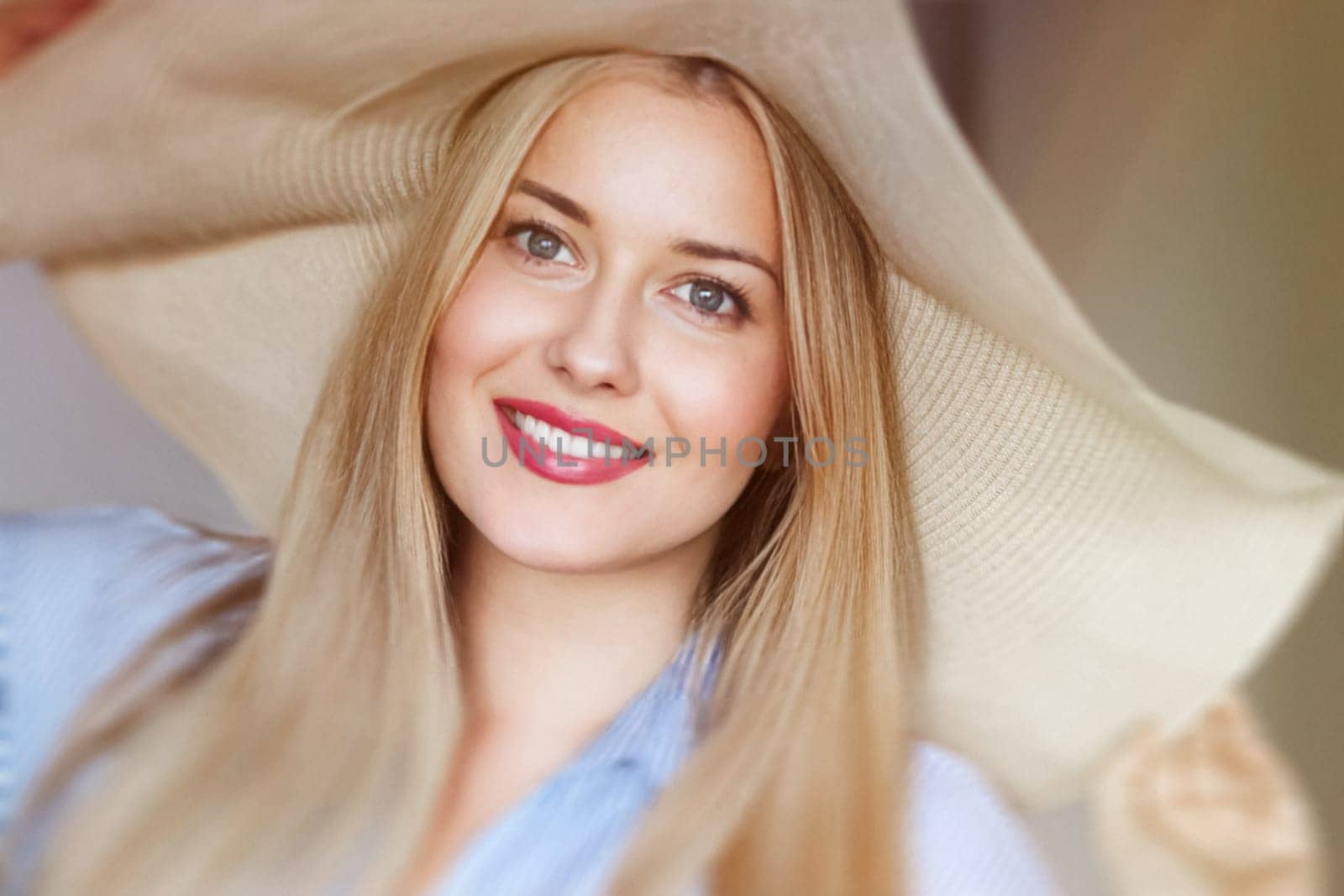 Woman, fashion and summer country charm, blonde beauty and elegance in wide brimmed beach hat. Feminine allure, timeless style and graceful glow. Smile, straw hat and blue striped blouse, natural lighting and effortless charm, fashion look idea