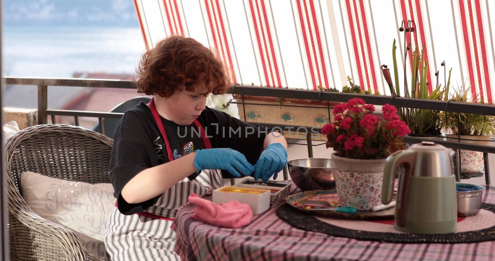 A young child focused on coloring Easter eggs using bright dyes and tools at a cozy outdoor table. The atmosphere is festive, perfect for decorating eggs.