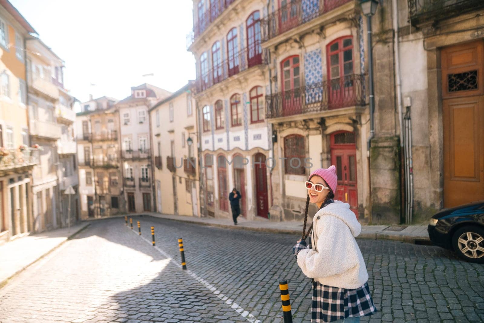 A beautifully sunny street located in a historic city, characterized by its charming cobblestones and vibrant buildings