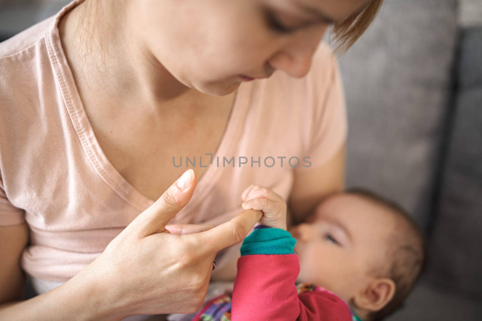 A mother lovingly feeds her infant in a warm and comfortable space.