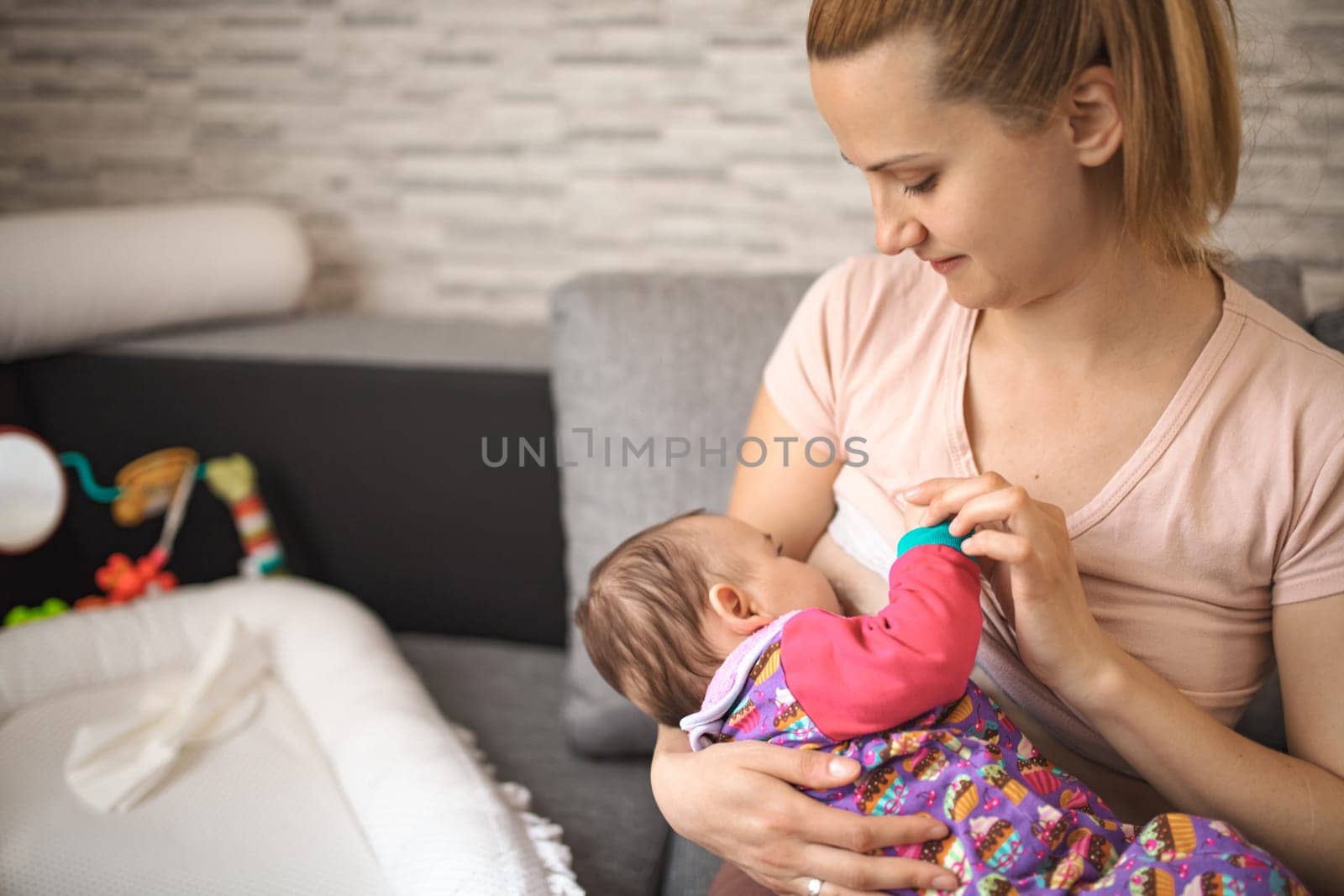 A mother lovingly breastfeeds her baby in a comfortable setting.