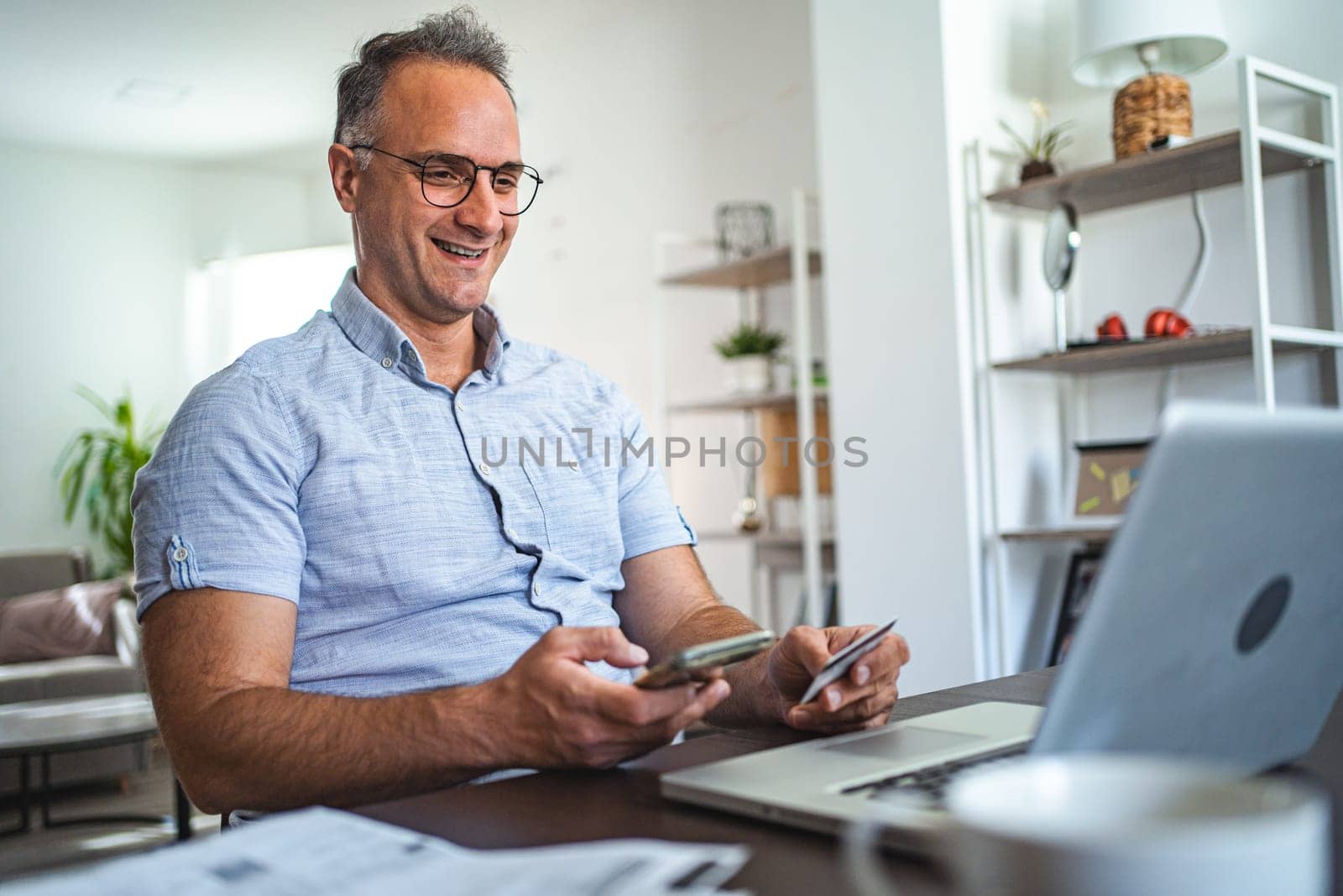Middle aged Caucasian man online shopping at home.