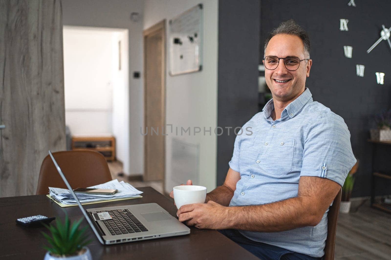 Middle aged Caucasian man working on laptop at home.