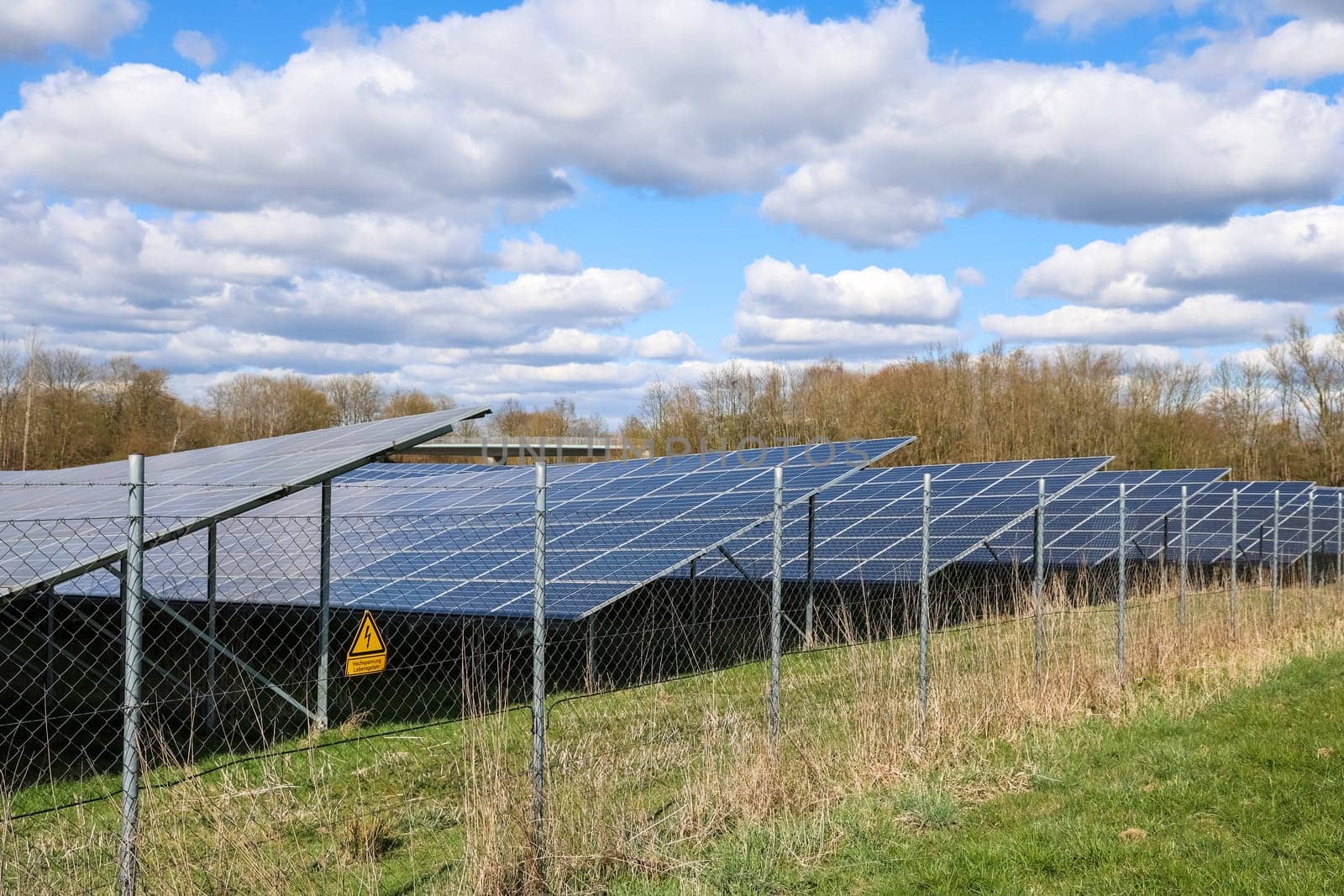 Photovoltaic panels generating electricity in a solar park, producing renewable energy under a cloudy sky
