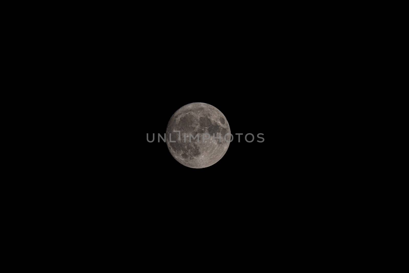 Nocturnal Reverie: Lunar Serenity in Telephoto Portrait.Embark on a journey of celestial wonder as the almost full moon is revealed in exquisite detail against the tranquil night sky.