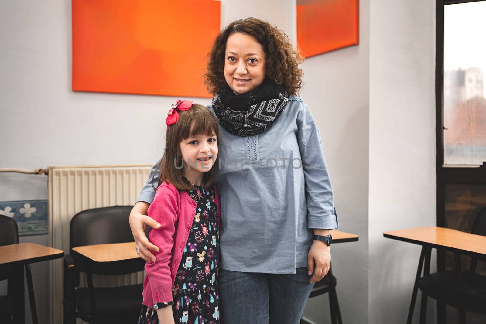 Female teacher with elementary student at language school class.