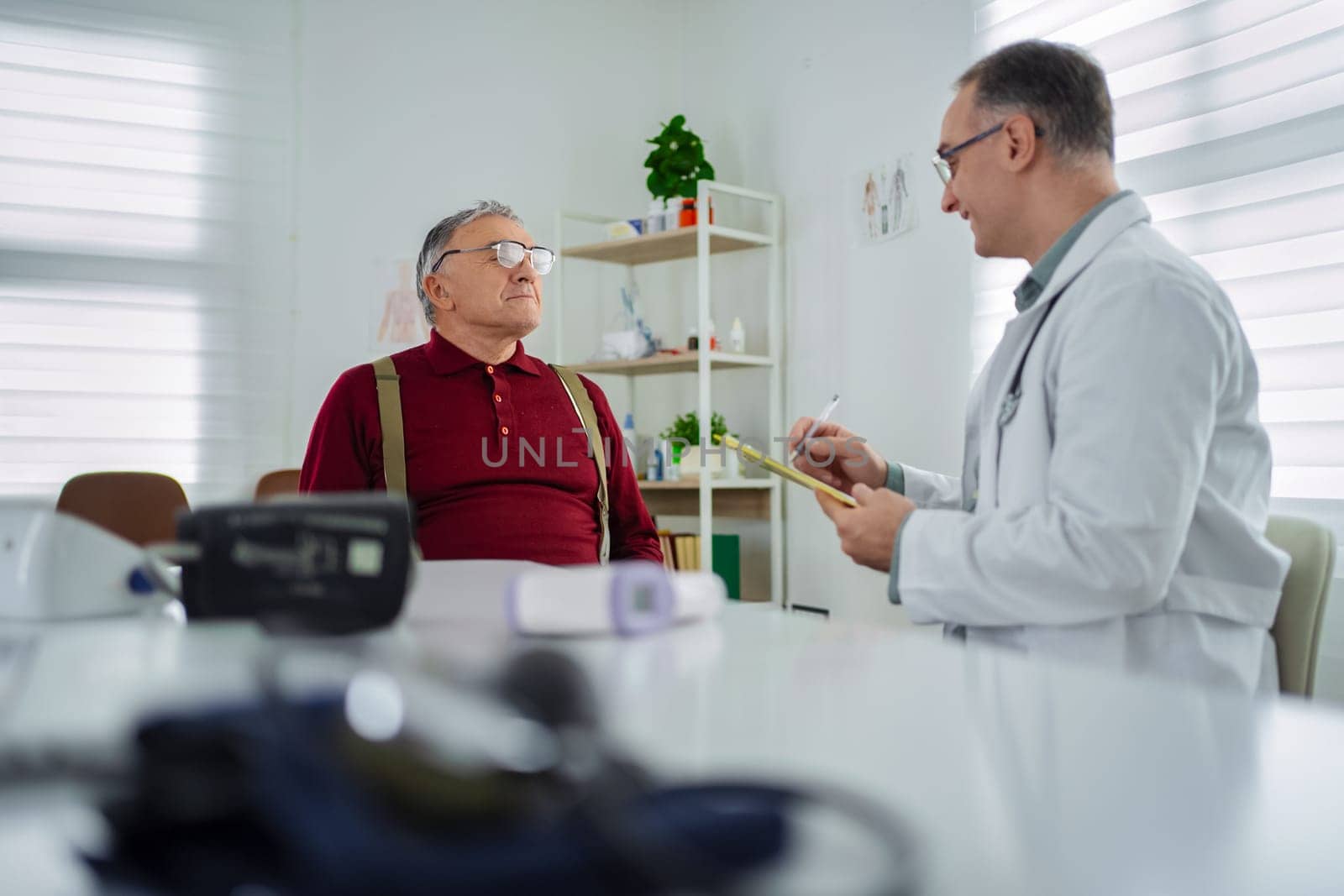 A healthcare professional engages with an older man during a checkup.
