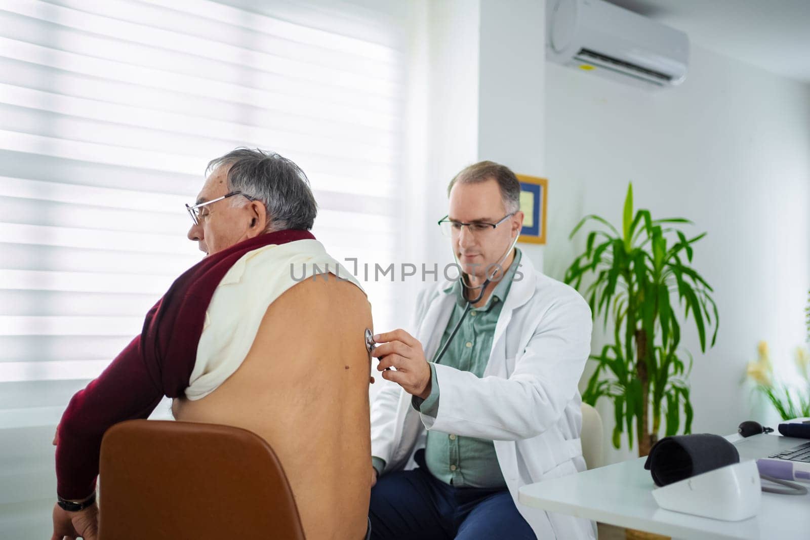 A healthcare professional conducts a check-up on an elderly man in a clinic.