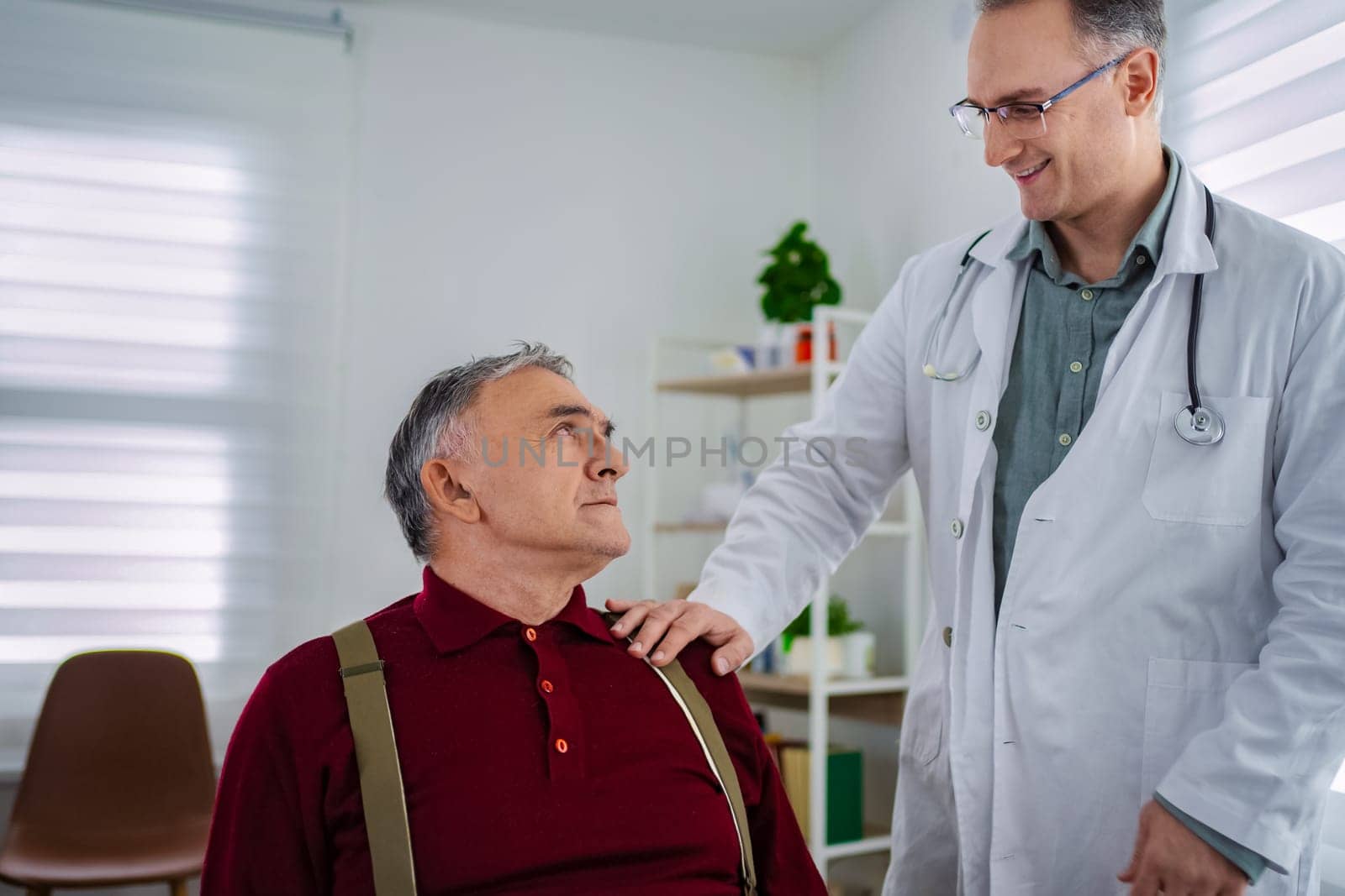 A doctor interacts warmly with an elderly patient in a clinic.