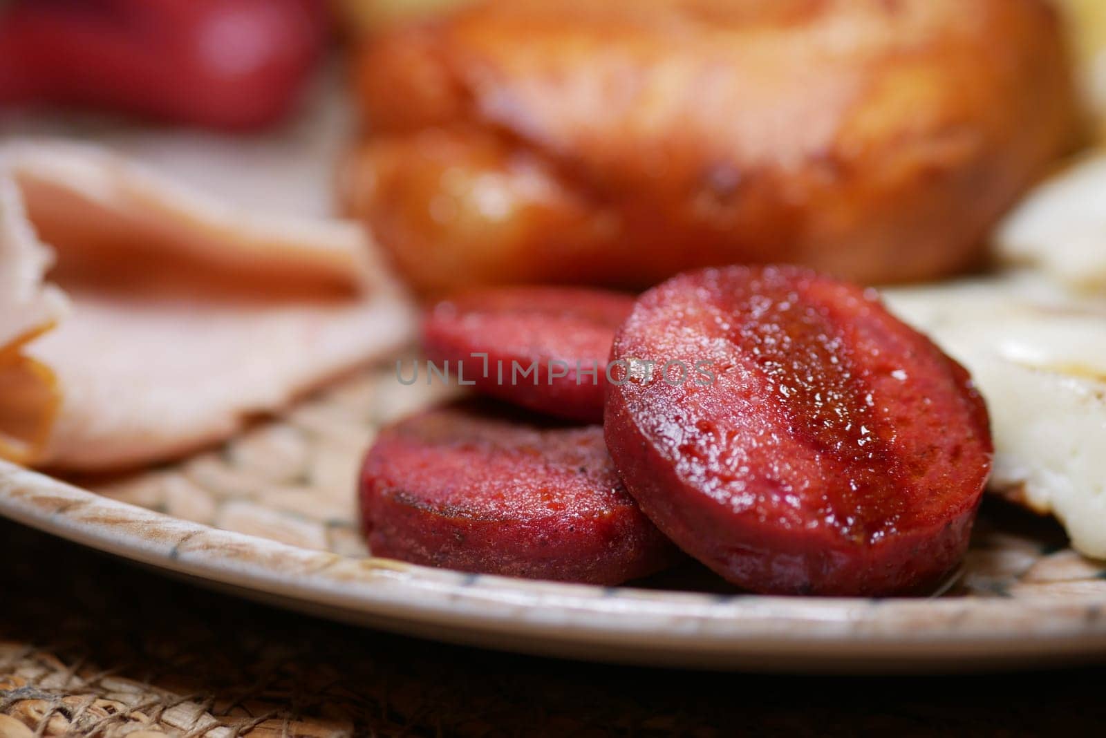 Grilled sausage slices served with bread and eggs on a warm plate.