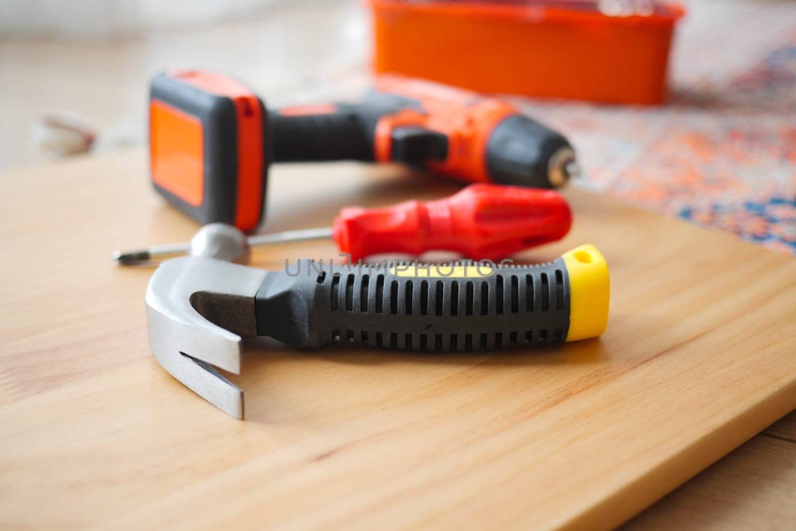 Various tools are arranged on a wooden surface for DIY projects.