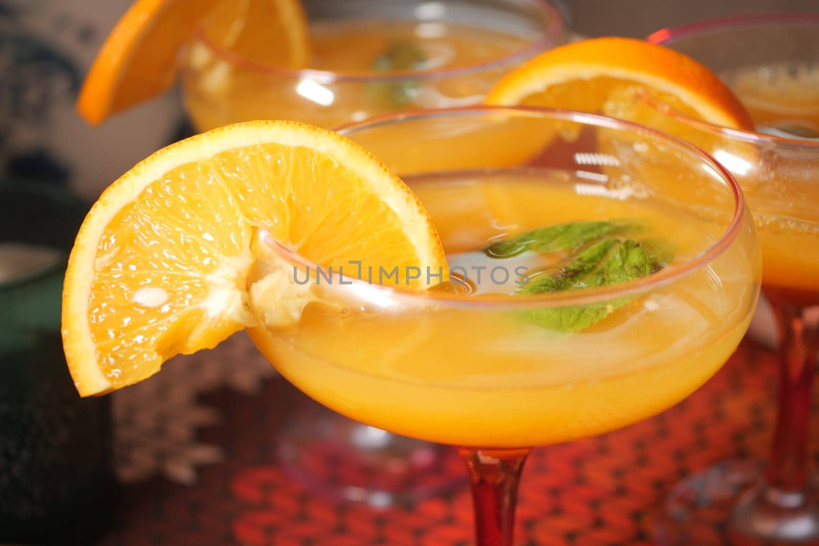 Colorful cocktails are served with orange slices and mint leaves for guests.