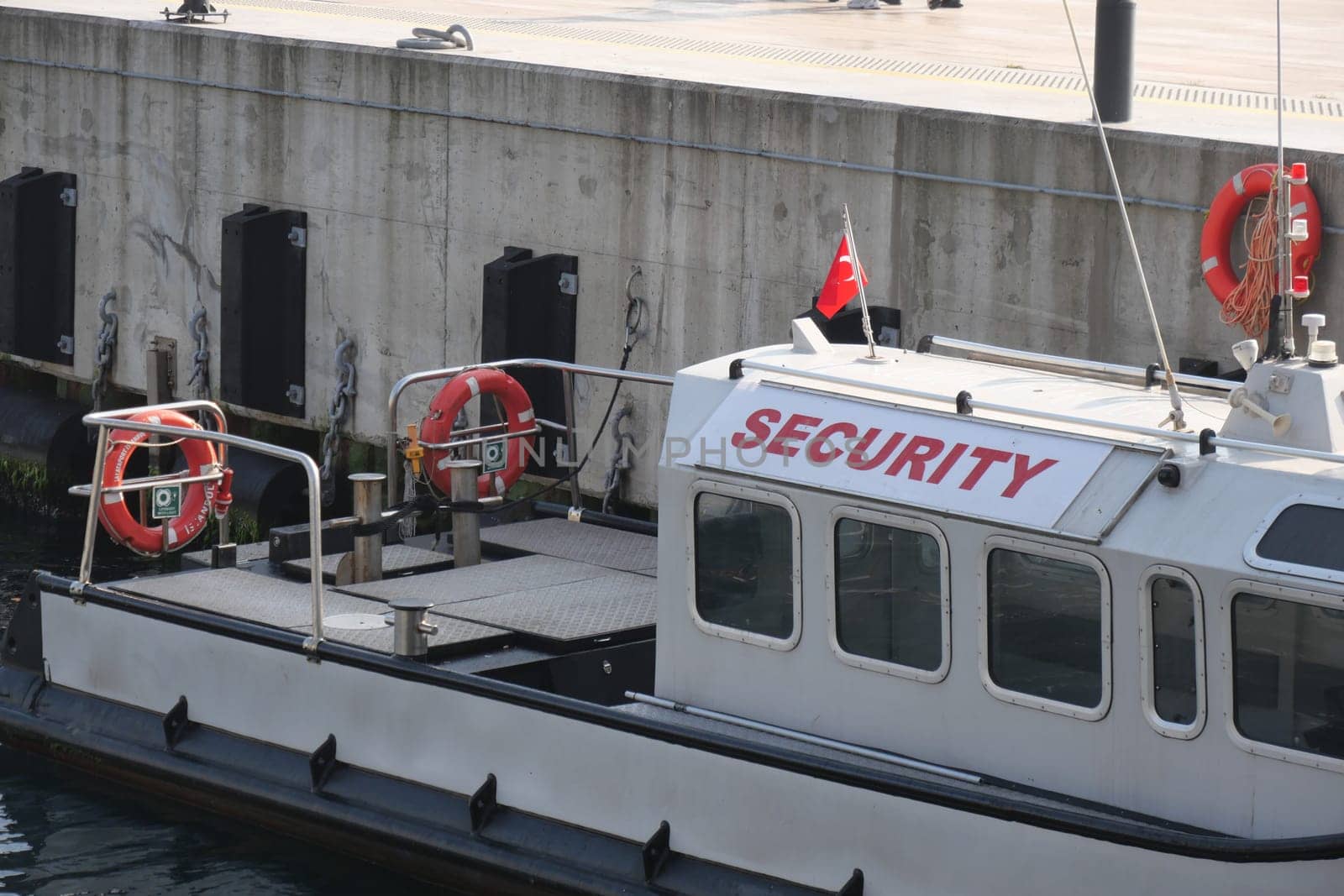 A security boat is docked at the harbor, ready for maritime safety operations.