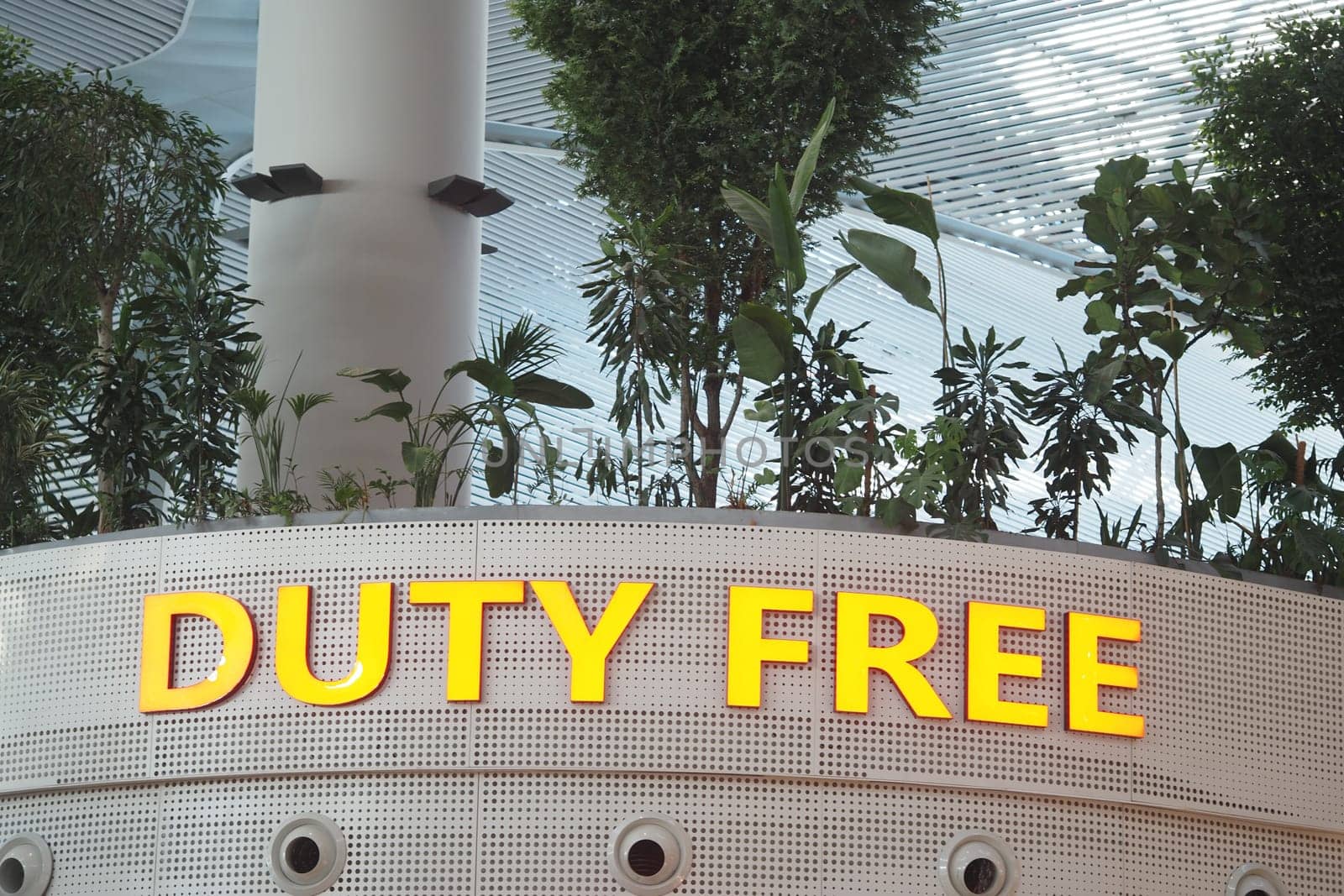 People browse through stores while enjoying greenery in the airport.