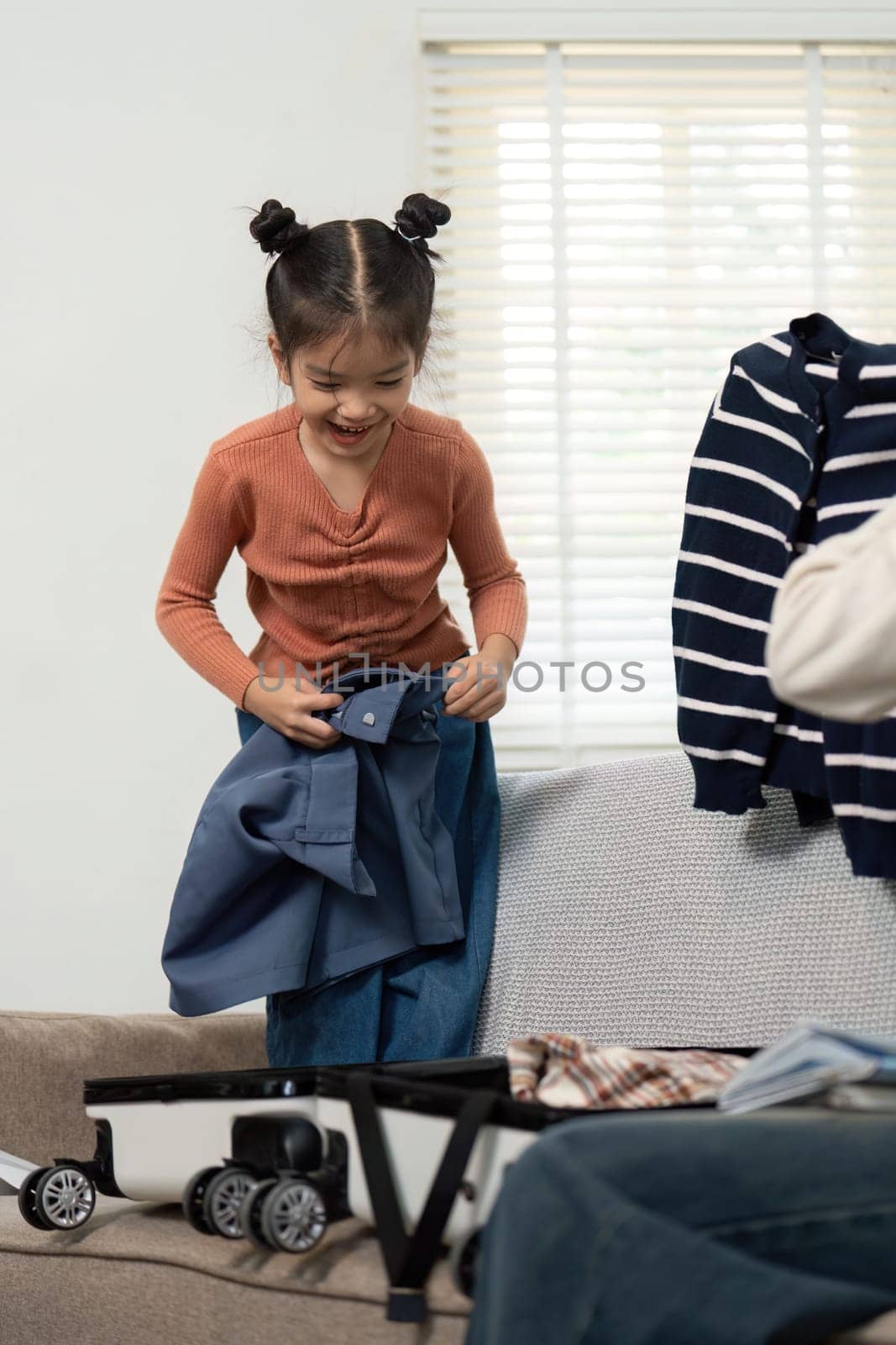 Capturing the enthusiasm of a child helping to pack, this image highlights family interaction and the delight that comes with preparing for a getaway.