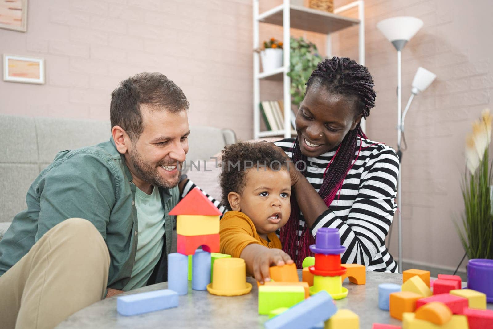 A family enjoys quality time together while building with colorful blocks.