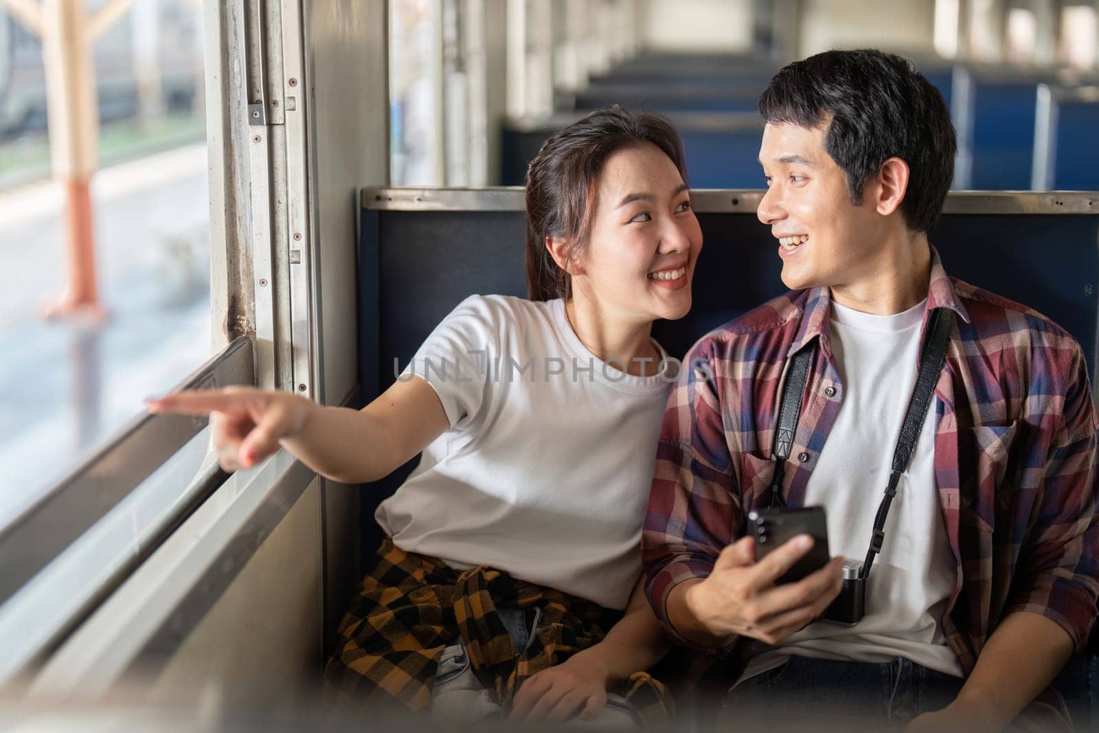 As the train rolls along, the woman points out the scenery, and they share smiles, capturing the essence of discovery and companionship.